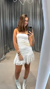 Vestido corto strapless blanco de encaje con volados en el ruedo.