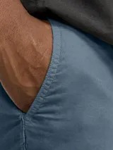 Short chino de lino color celeste, de corte relajado, cintura media y ajuste cómodo. Cuenta con cintura elástica con cordón ajustable, bolsillos frontales y traseros funcionales.