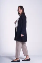 Saco tejido color crema con diseño de ochos y bolsillos frontales.