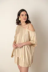 Blusa italiana color dorado, de corte irregular y un hombro descubierto. Diseño holgado y mangas cortas.