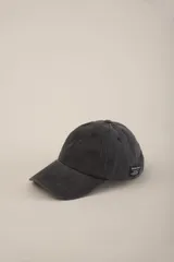 Gorra de béisbol negra con visera curva y ajuste trasero con hebilla metálica.