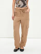 Pantalón negro de corte holgado con cintura elástica ajustable con cordón, bolsillos laterales y bolsillos tipo cargo en los laterales de las piernas.
