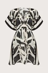 Poncho corto con estampado geométrico en blanco y negro, escote en V y mangas amplias.