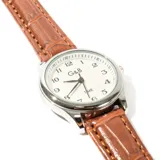 Reloj de pulsera con correa marrón símil cuero, caja plateada y esfera blanca con números arábigos.