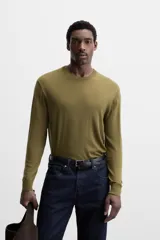Jersey negro de lana con acabado mercerizado, corte relaxed fit, cuello redondo y manga larga con terminaciones en rib.