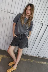 Remera gris lavado de corte boxy con costuras en color contrastante y bordado de una estrella en el frente.