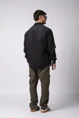 Chaqueta de jean celeste de corte recto, con cuello clásico, cierre frontal con botones metálicos y bolsillo de parche en el pecho.