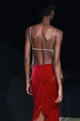 Falda midi de terciopelo color borgoña, de tiro alto y corte recto. Tiene una abertura en la parte trasera y cierre de cremallera oculta en la costura.