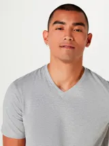 Camiseta básica unisex de color beige, con cuello en V y sin costuras laterales para mayor comodidad.