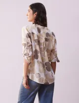 Blusa de algodón estampada marca Dash, con cuello a la base, escote en V y abertura con botones. Tiene un bolsillo en la parte delantera y mangas 3/4 regulables con presilla y botón.