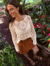 Buzo tejido color crudo con mangas largas y calado en el frente.