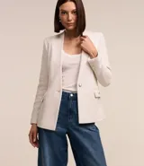 Blazer color crema en tejido tweed, de corte recto, sin solapa, con cierre frontal de un botón y bolsillos con solapa.