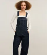 Mono jeans modelo peto confeccionado con algodón más sostenible. La prenda tiene piernas rectas, breteles anchos ajustables, bolsillo en el pecho y costuras contrastantes.