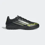 Championes de fútbol Adidas modelo F50 Club para pasto sintético, color negro con detalles en amarillo flúor y plateado. Presentan un exterior Fiberskin con estampado Sprintgrid y suela de caucho con tacos bajos.