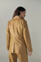 Blazer lila de lino con ruedo curvo, solapas con muesca, cierre frontal con un botón, bolsillos ojal con solapa y tajo en la espalda.