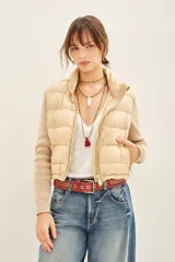 Campera color beige con mangas tejidas, cuello alto y cierre frontal.