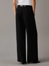 Pantalón negro de crepé elástico, corte recto, cintura plisada, bragueta con cremallera y bolsillos con ranura.