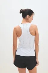 Musculosa deportiva blanca con logo pequeño en el pecho.