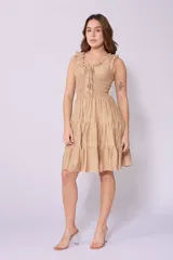 Vestido corto rojo con escote fruncido, tirantes anchos con volantes y cuerpo de nido de abeja. Falda con diseño escalonado.