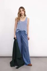 Pantalón ancho de lino color vino, con tiro medio y elástico en la cintura. Presenta una pierna ancha tipo elefante con un refajo inferior para mejorar la caída.