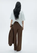 Pantalón de vestir marrón con diseño de cuadros, cintura elástica con cordón de ajuste, corte recto y bolsillos laterales.