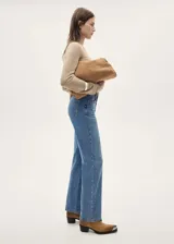 Pantalón de jean celeste de tiro medio, corte recto, cinco bolsillos y tachuelas decorativas.