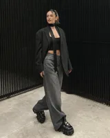 Borcego negro de cuero con plataforma track y detalles metálicos. Ajuste con cordones y hebillas.