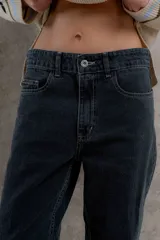 Pantalón jean de tiro medio color negro, corte mom, con bolsillos delanteros y traseros.
