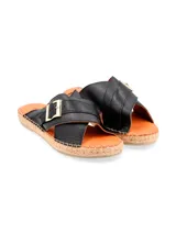 Sandalias negras de cuero con tiras cruzadas y hebilla dorada.