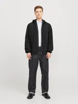Campera negra liviana con capucha ajustable, cierre frontal con cremallera y bolsillos delanteros con cierre. Puños de canalé.