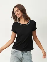 Remera blanca de algodón con cuello redondo y detalle de strass plateado.