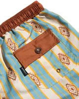 Short de baño de microfibra con estampado de rayas verticales en tonos celeste y beige, con motivos geométricos en color ocre. Tiene cintura elastizada marrón con cordón ajustable, dos bolsillos laterales y uno trasero.