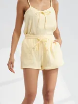 Short de tela color amarillo pastel con cintura elastizada y lazo de ajuste.