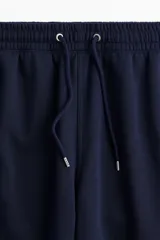 Pantalón de jogging azul marino de felpa liviana con interior cepillado suave, corte regular, cintura elástica con cordón, bolsillos laterales y puños acanalados.