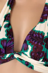 Top de bikini con estampado floral en tonos morado, verde y blanco. Diseño halter con tiras para atar en el cuello y espalda.