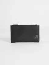 Billetera pequeña de cuero sintético texturizado color verde azulado, con cierre superior de cremallera y un pequeño logo metálico en la parte frontal inferior derecha.