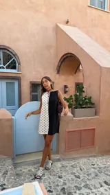 Vestido corto con escote recto, diseño color block en verde claro y marrón, sin mangas y con bolsillos laterales ocultos.