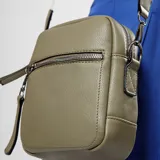 Bandolera color verde oliva con correa larga regulable de cinta beige con detalles en verde.
