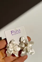 Caravanas de porcelana hechas a mano, con diseño de flores metálicas, cada pieza es única.