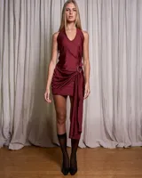 Vestido corto color terracota con escote halter y lazo lateral que se cruza a través de una hebilla metalizada.