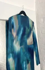 Vestido midi de cuello alto, color azul con estampado abstracto en tonos celeste, blanco y verde.