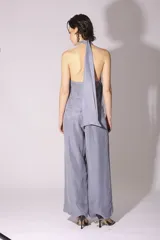 Conjunto de pantalón y top de seda color gris, con cuello halter y corte holgado.