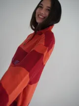 Sweater de hilo de algodón a rayas horizontales rosas y grises, con cuello polo, botones de guampa y bordado de Sierra Mora a tono.