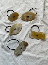 Set de tres coleros con apliques de guampa en tonos claros.
