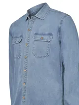Camisa de denim azul de manga larga con doble bolsillo en el pecho con tapeta y botones de madera.