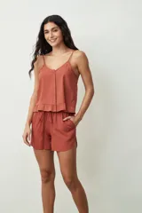 Short negro de tiro alto con cordón ajustable en la cintura y bolsillos laterales. Presenta un corte holgado y ruedos redondeados.