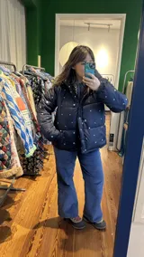 Campera puffer azul marino con estampado de motivos náuticos en blanco, rojo y verde.