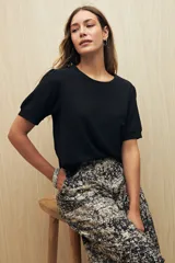 Top negro de manga corta con textura acanalada sutil y cuello redondo.