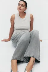 Musculosa de punto color gris claro, con cuello redondo y sin mangas. Decorada con strass plateado de diferentes tamaños.