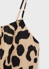 Vestido corto con tirantes finos y estampado animal print en tonos beige y negro.